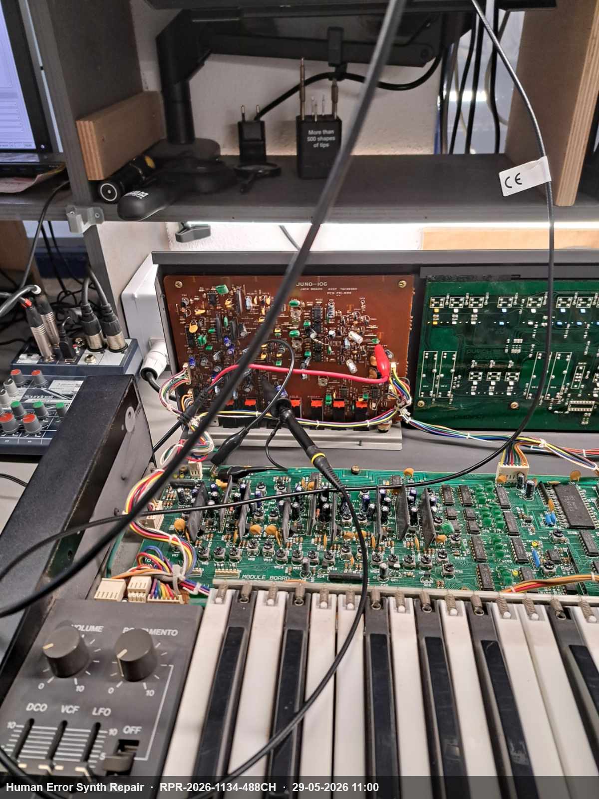 Juno-106 volledig opengemonteerd op de werkbank, met oscilloscoop-probes aangesloten op de losse Jack board en module board.