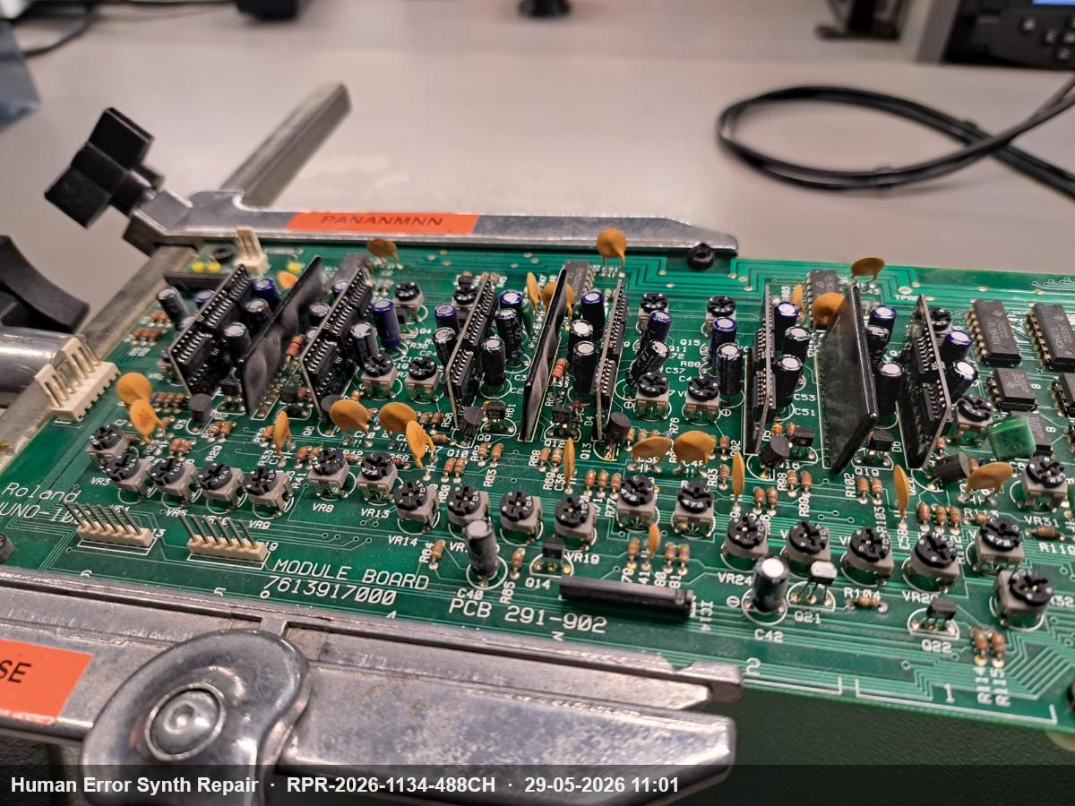 Roland Juno-106 module board PCB 291-902 vastgeklemd in een werkklem, klaar voor soldeerwerkzaamheden.