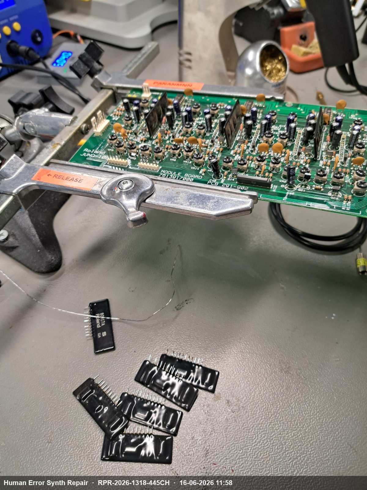 Module board in een bankschroef geklemd, met vijf verwijderde AR80017 IC's losliggend op de werktafel.