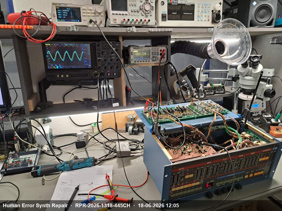 Werkplaatsopstelling met Rigol-oscilloscoop met sinusgolf op scherm, multimeter en open Juno-106 rackbehuizing aangesloten voor kalibratie.