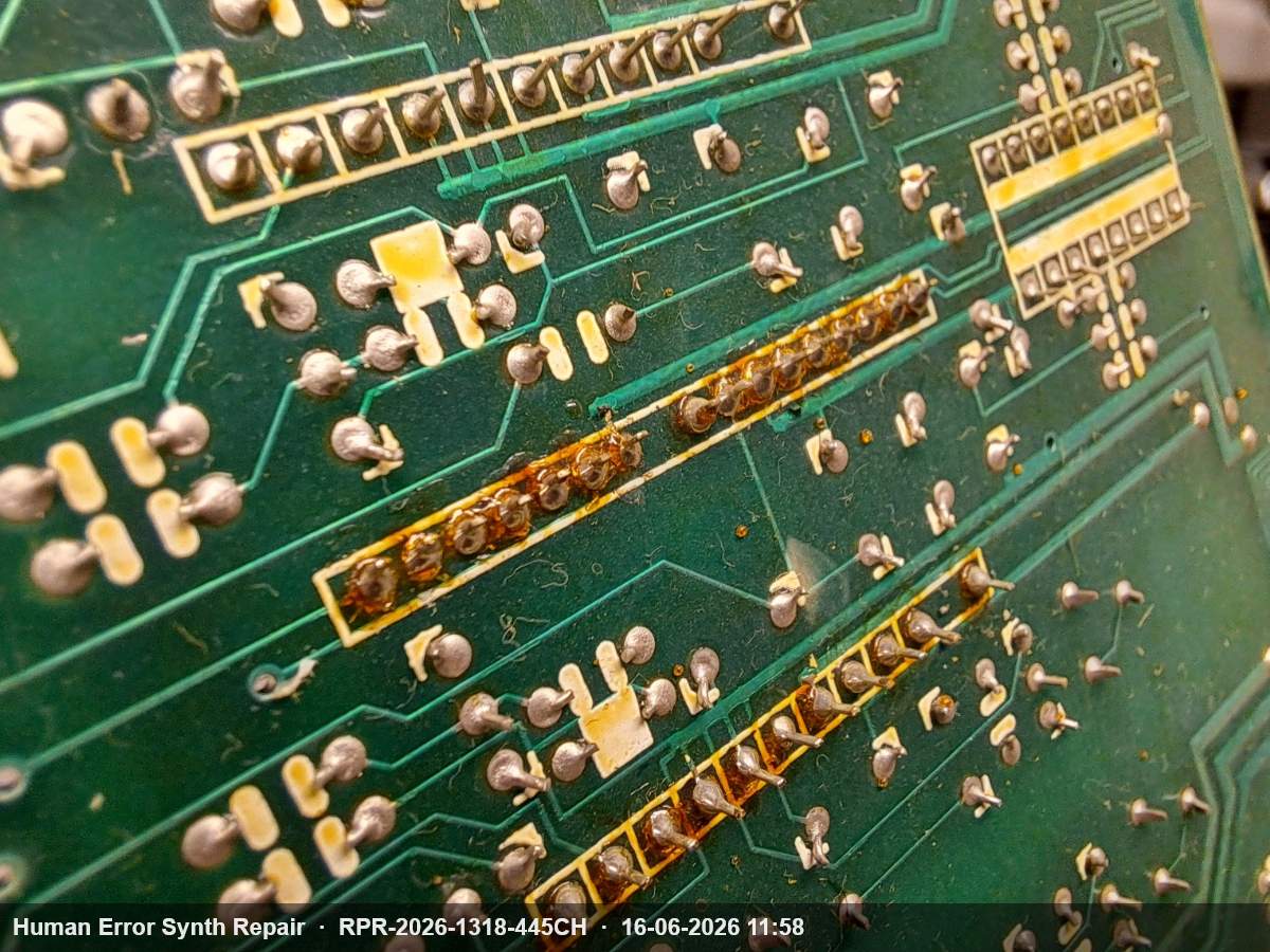 Onderzijde van het module board met zichtbare ontgassing en bruine vlekken langs de IC-rijen.