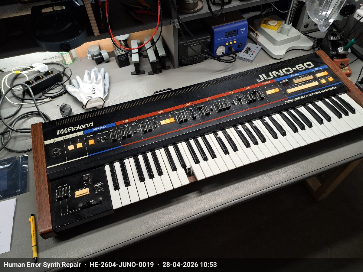 Roland Juno-60 volledig zichtbaar op de werkbank bij binnenkomst, houten zijpanelen en zwart frontpaneel.