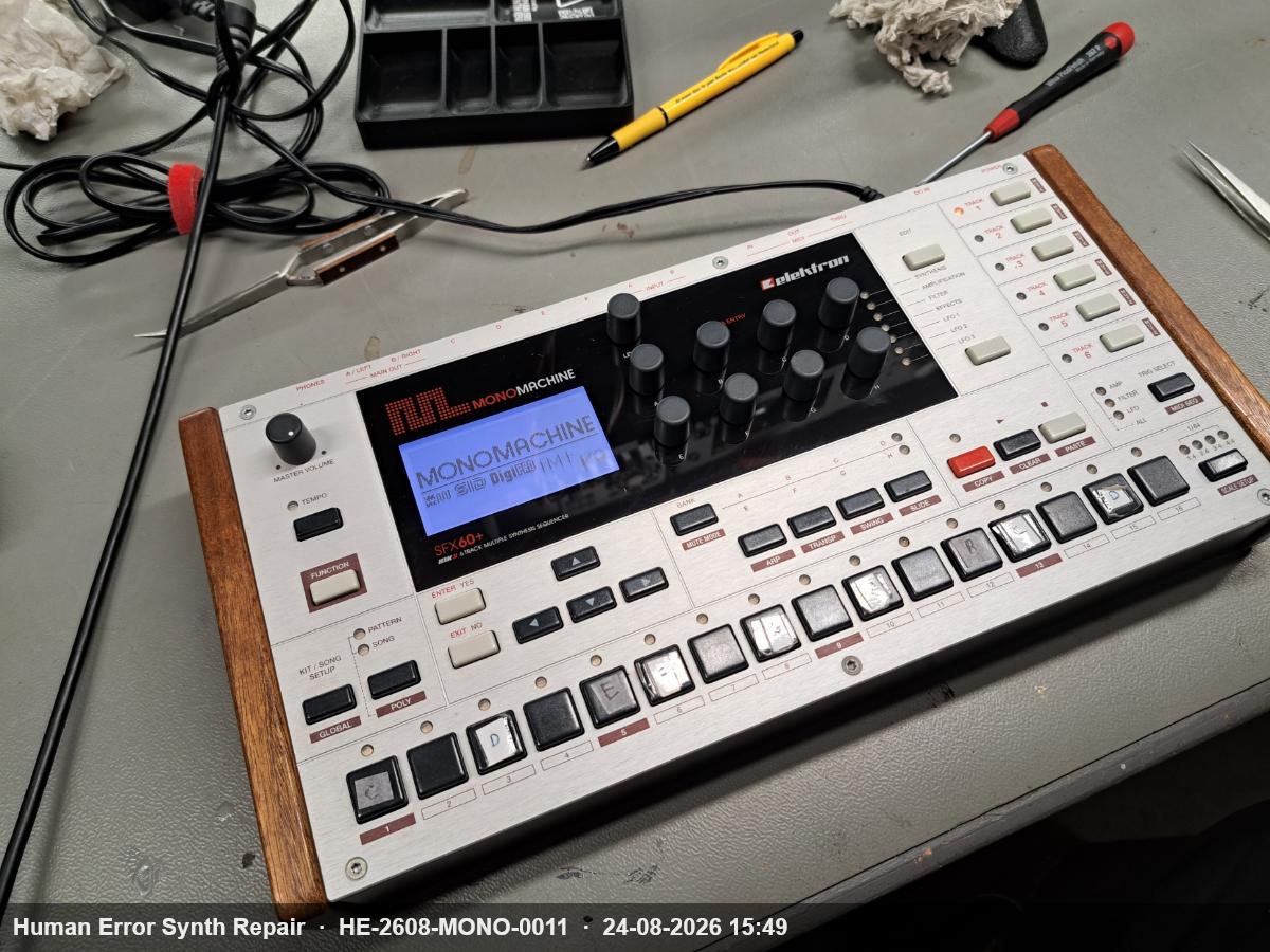 Elektron Monomachine SFX60+ MKII op de werktafel, volledig gemonteerd, display toont het opstartscherm met MONOMACHINE-logo.