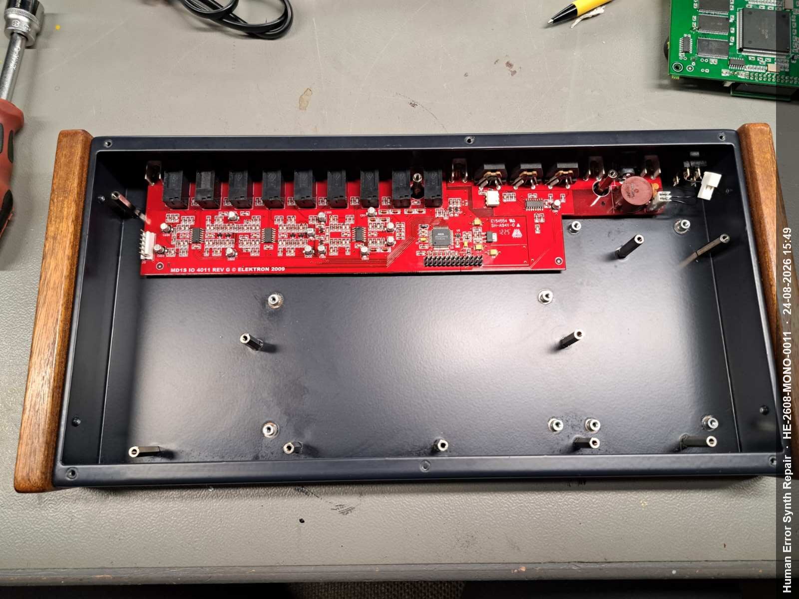 Lege zwarte Monomachine-behuizing met alleen het rode IO-board zichtbaar aan de rechterzijde.
