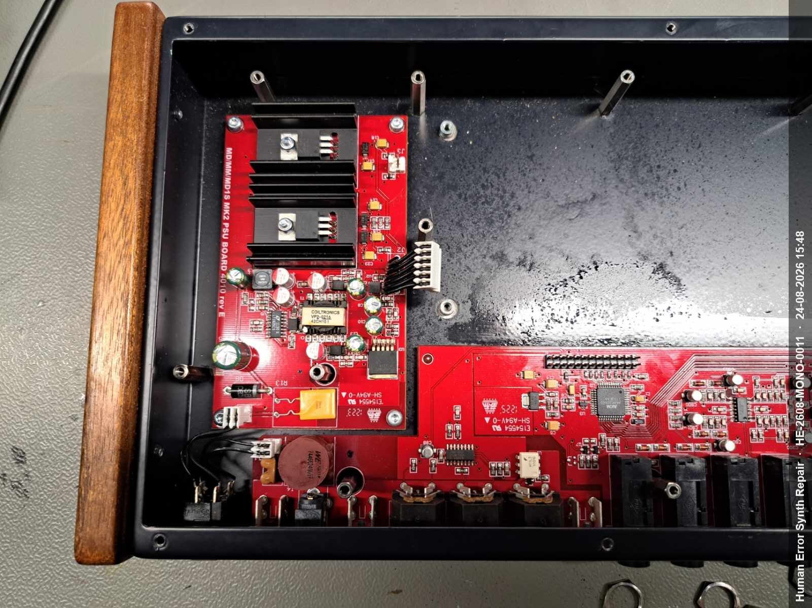 Rood MD/MM/MD1S MK2 PSU BOARD 4010 Rev E in de geopende Monomachine-behuizing met koellichaam zichtbaar.