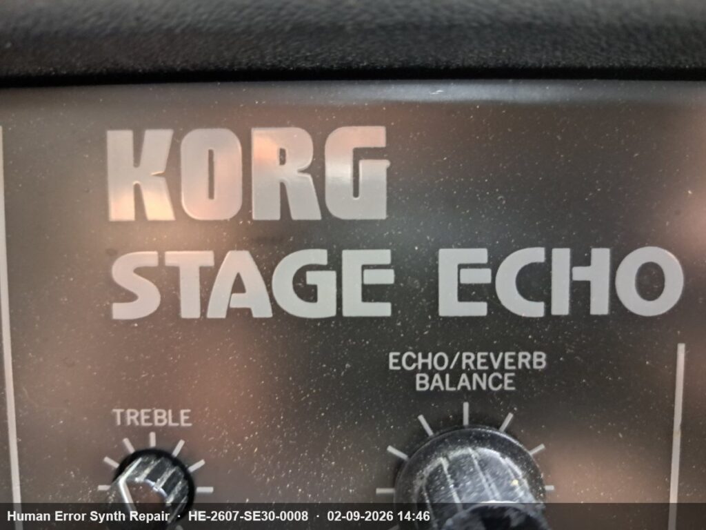 Close-up van het Korg Stage Echo naamplaatje op het frontpaneel met daaronder de Treble- en Echo/Reverb Balance-knoppen.