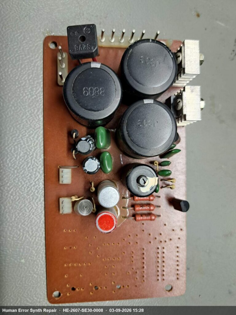 Voedingsbord van de SE-300 met drie grote zwarte elektrolytische condensatoren uit de jaren tachtig en originele componenten.